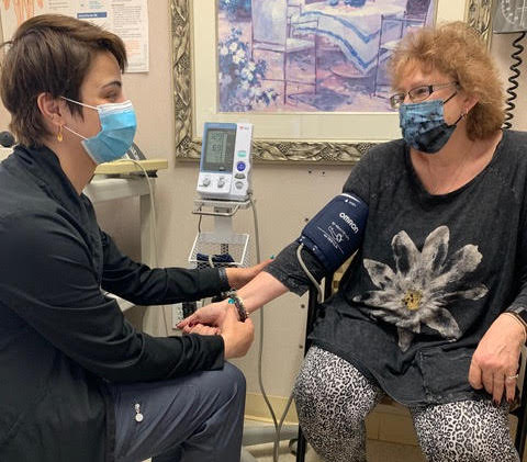 doctor checking patient blood pressure