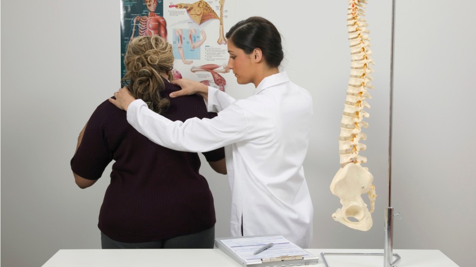 doctor with hands on patients upper back